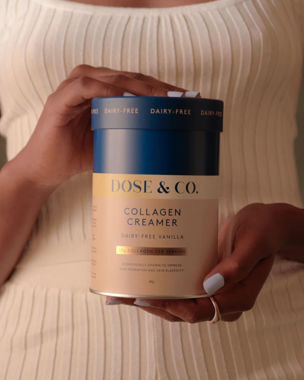 Person holding a container of Dose & Co. Collagen Creamer.