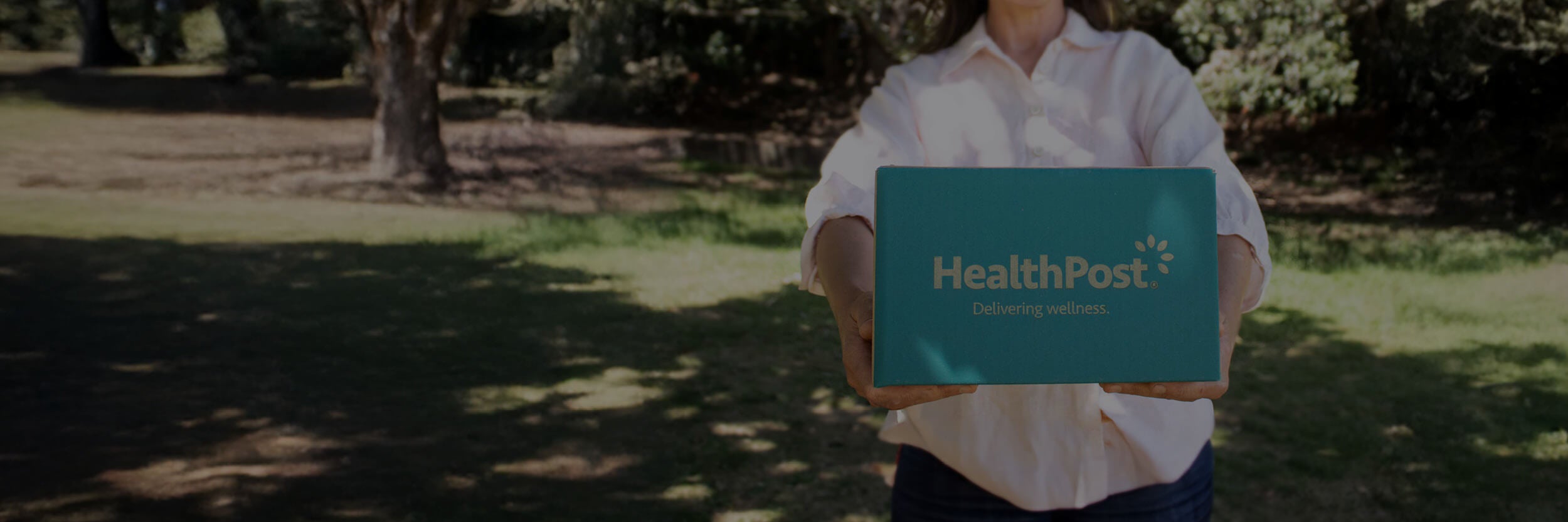 Person holding a 'HealthPost' sign outdoors
