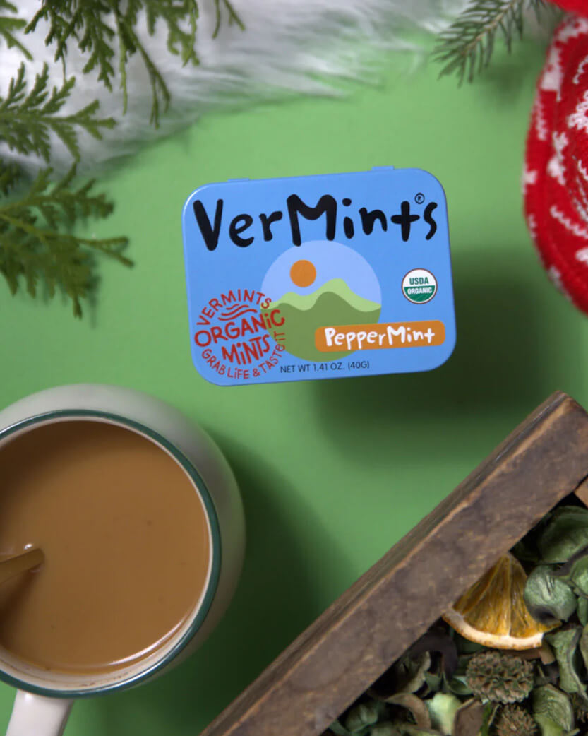VerMints organic peppermint label on a green background with a cup of coffee and herbs.