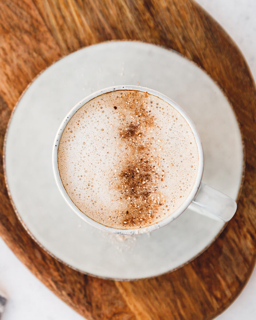 Cappuccino in a white cup on a wooden surface