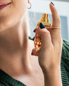 Hand holding a perfume bottle with a blurred background.