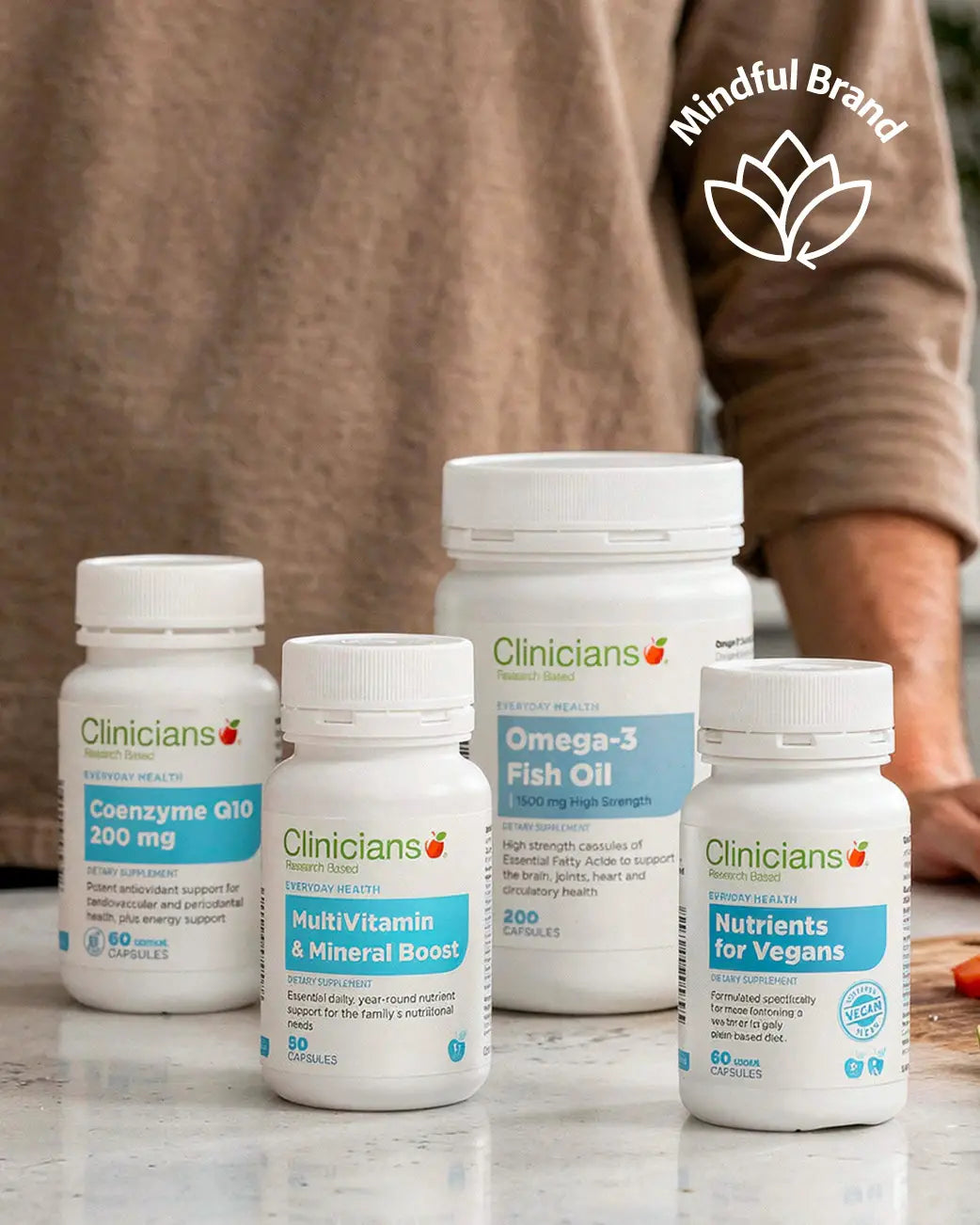 Four Clinicians supplement bottles on a marble surface with a blurred person in the background.
