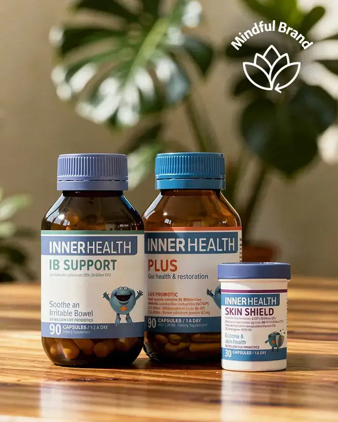 Three Inner Health supplement bottles on a wooden surface with a blurred plant in the background.