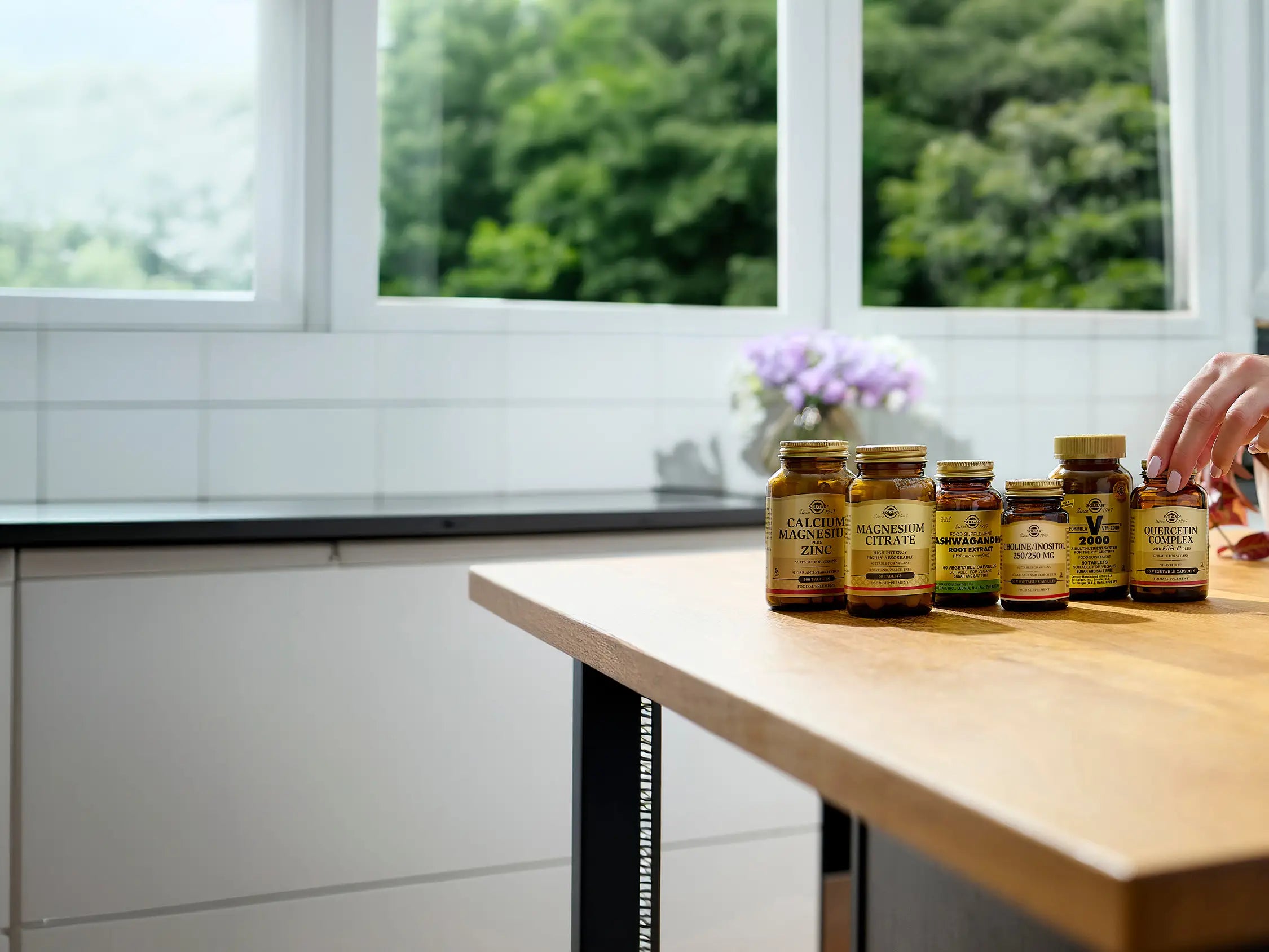 Supplement bottles on a kitchen counter with a window in the background