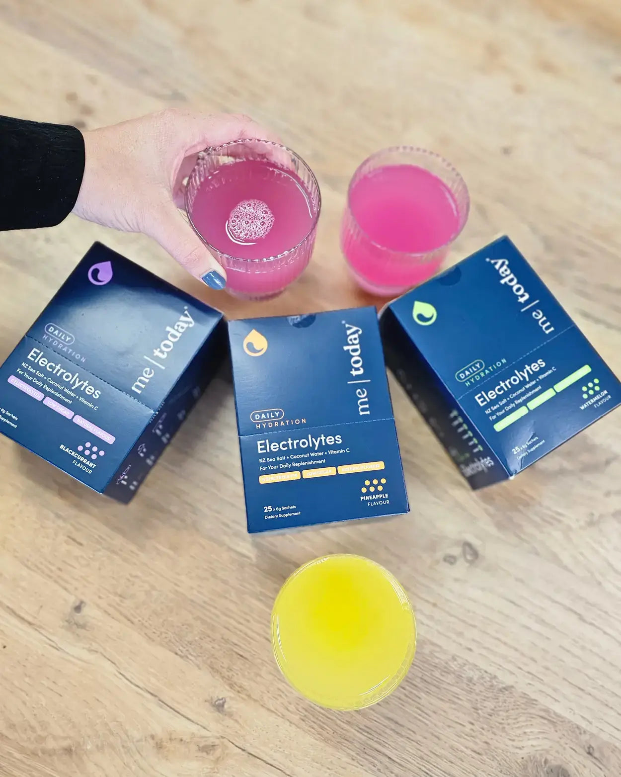 3 Me Today Electrolyte boxes on a table with 3 glasses.