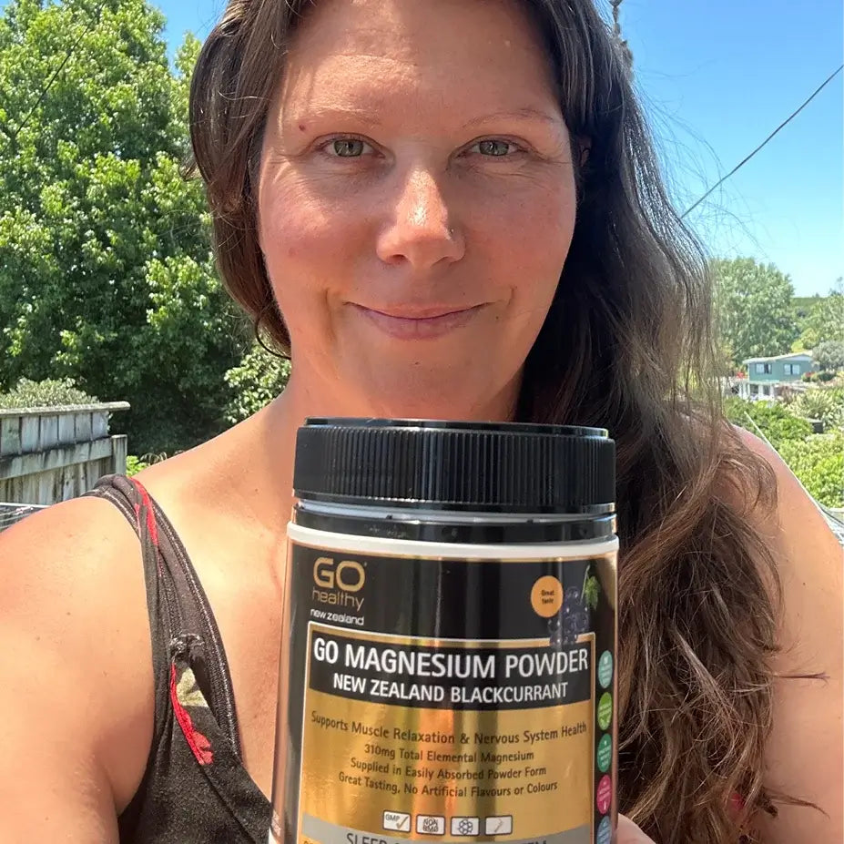 Woman holding GO Healthy GO Magnesium Powder in an outdoor setting.