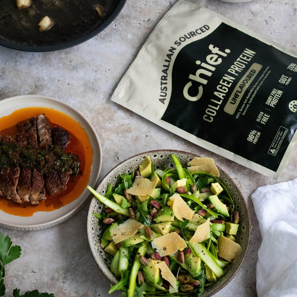 Dish of salad with a bowl and protein powder on a textured surface.