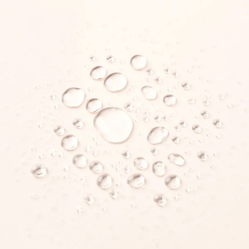 Water droplets on a light pink background.