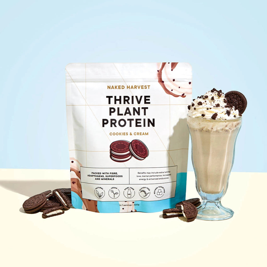 Naked Harvest Thrive Plant Protein package with a cookies and cream flavor, next to a milkshake and cookies on a light background.