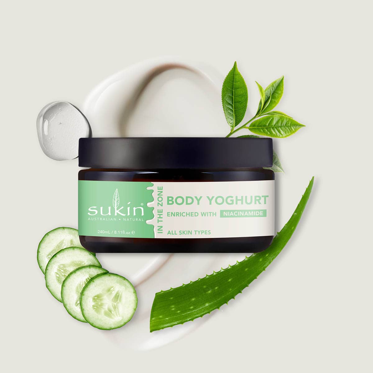 Sukin Body Yoghurt jar with cucumber slices and aloe vera leaves on a light background.