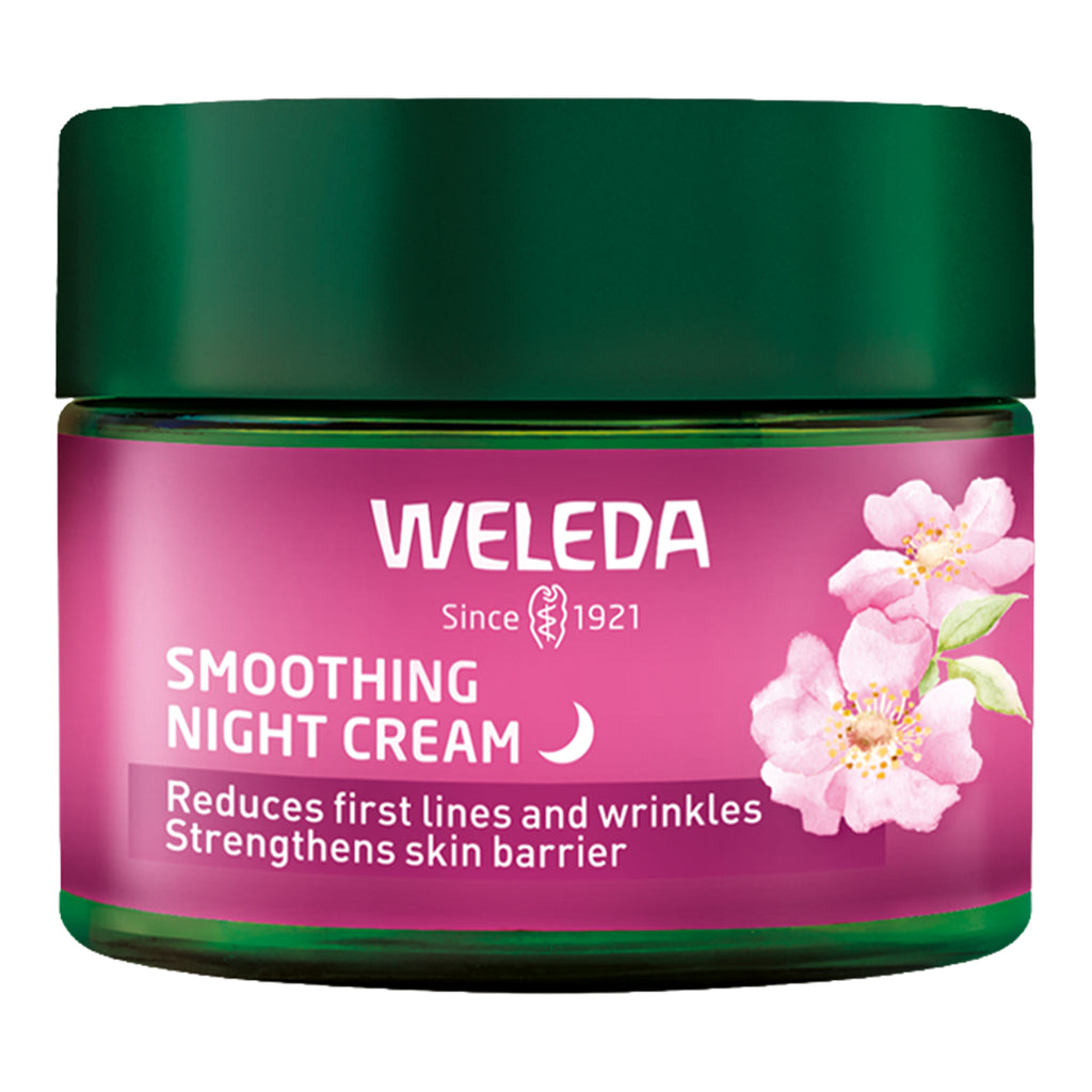 Weleda smoothing night cream jar with pink label and green lid on a white background.